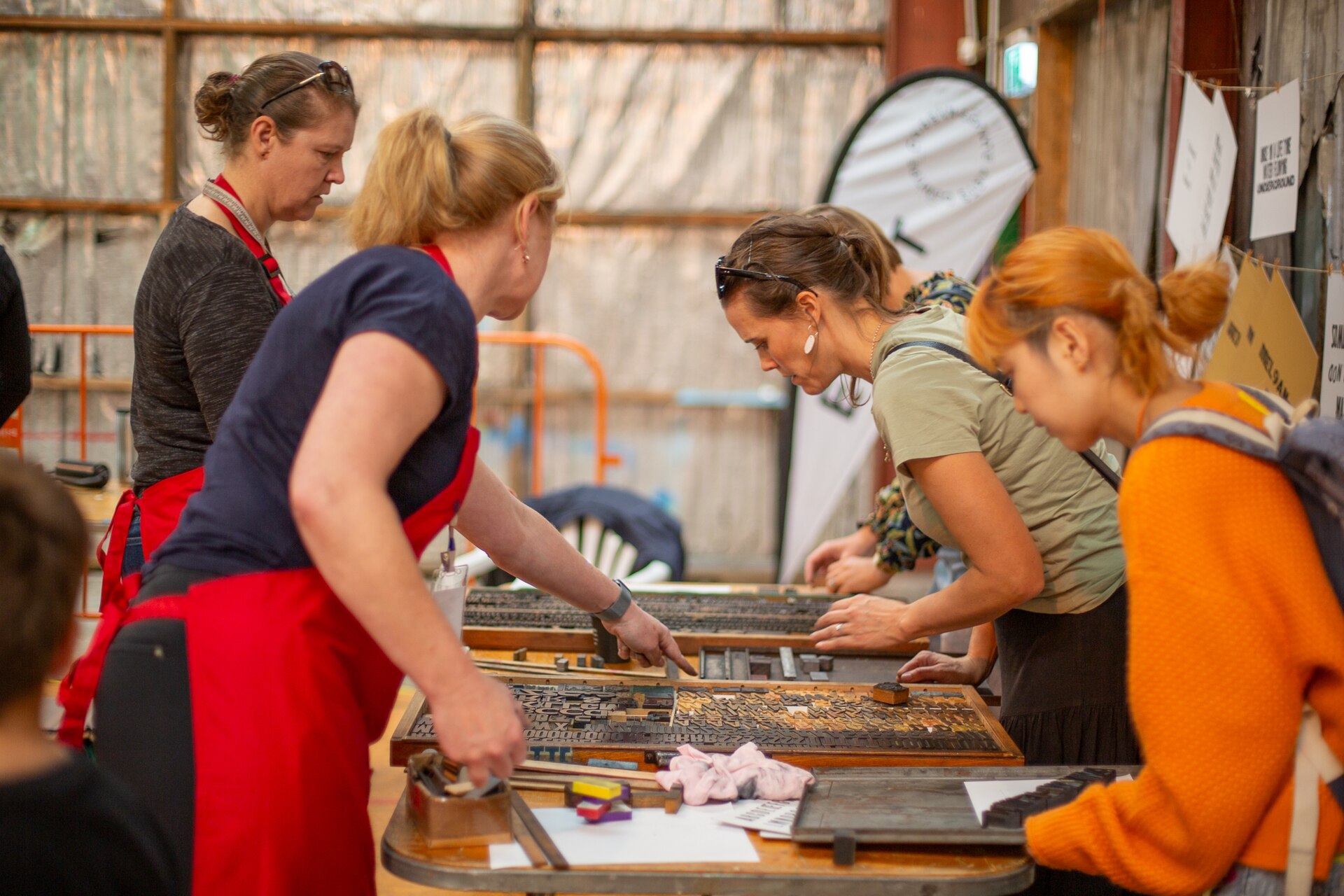 Participants working on letterpress printing at Printopia 2024